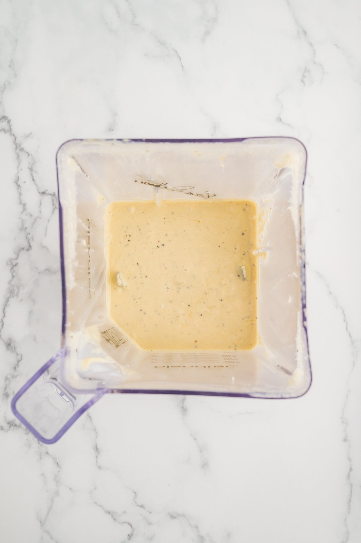 Creamy homemade Caesar dressing fully blended and ready to use in a clear blender