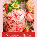 Strawberry butter is swirled in a glass jar with streaks of red berry juice visible throughout.